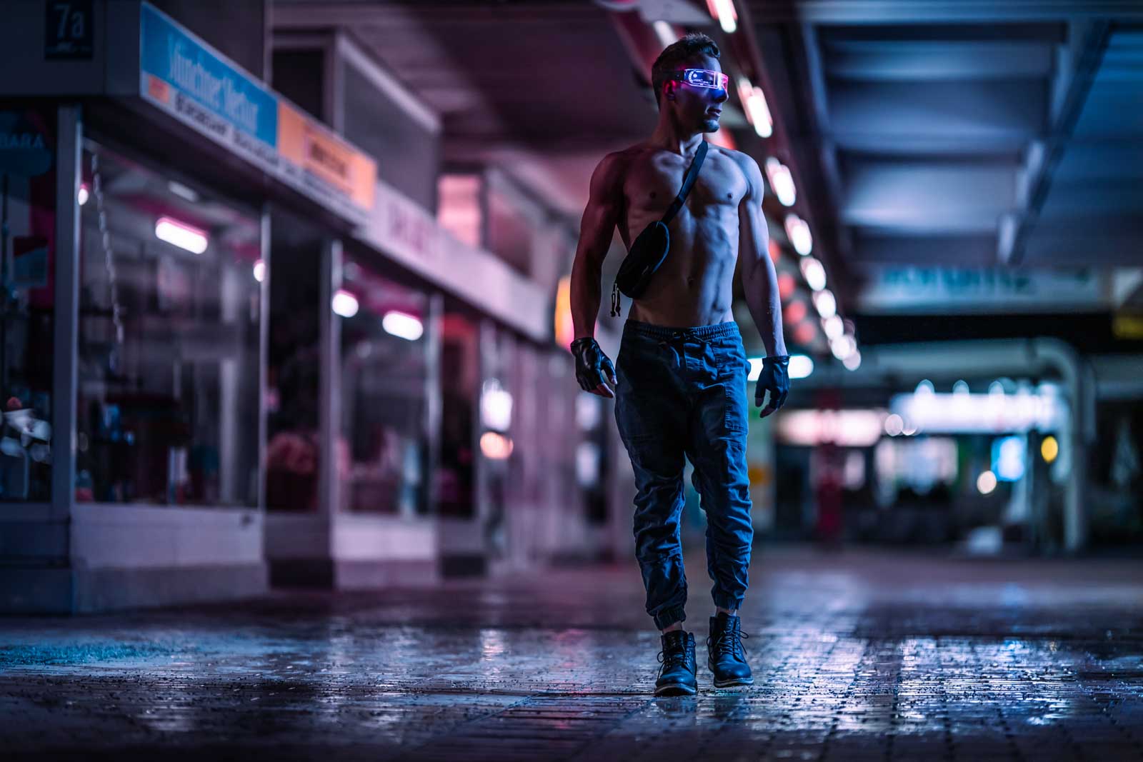 Fitness Fotoshooting bei Nacht: Muskulöser Mann läuft durch Nasse Straße.