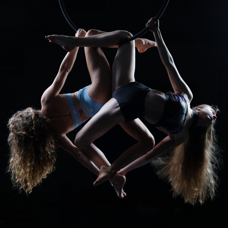 Zwei Turnerinnen am Aerial Hoop werden im Studio fotografiert.