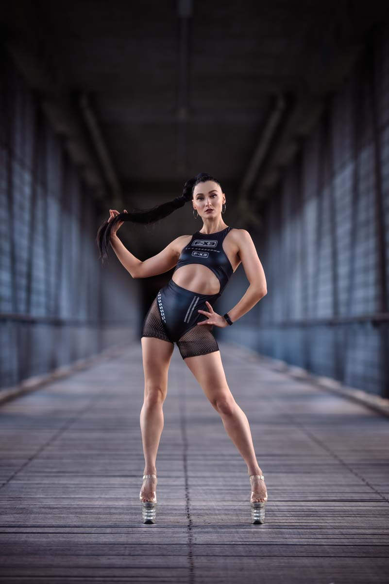 Tänzerin in eleganter Pose in einem Tunnel.