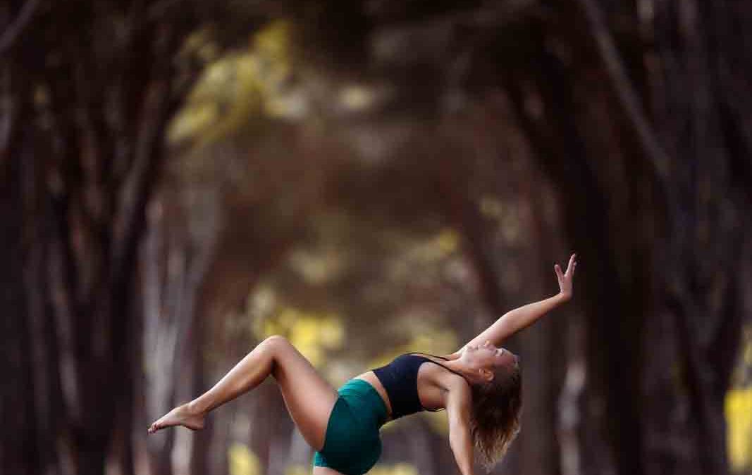 Tänzerin auf einem Bein vor beeindruckender Allee