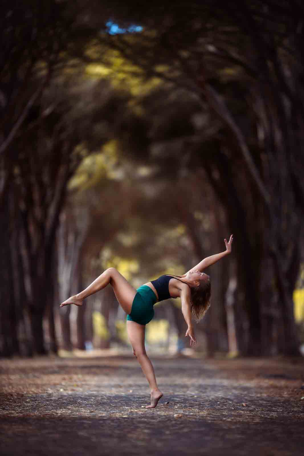 Tänzerin auf einem Bein vor beeindruckender Allee