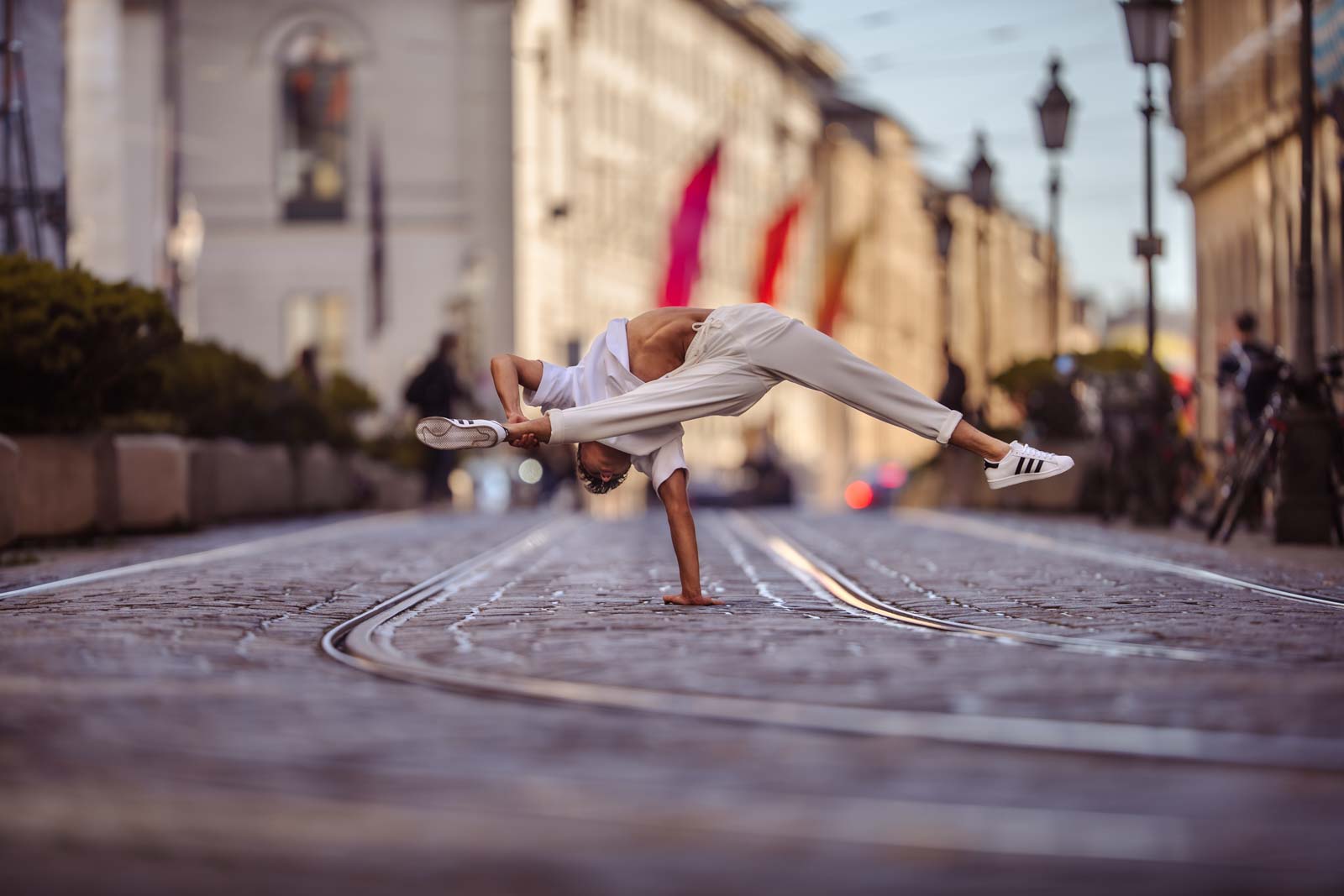 Akrobat steht auf der Straße auf einem Arm.